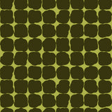 Wallpaper in a repeating blot print in dark green on a green field.