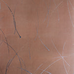 Detail of a wallpaper in an elongated paint splatter pattern in metallic navy on a rust field.