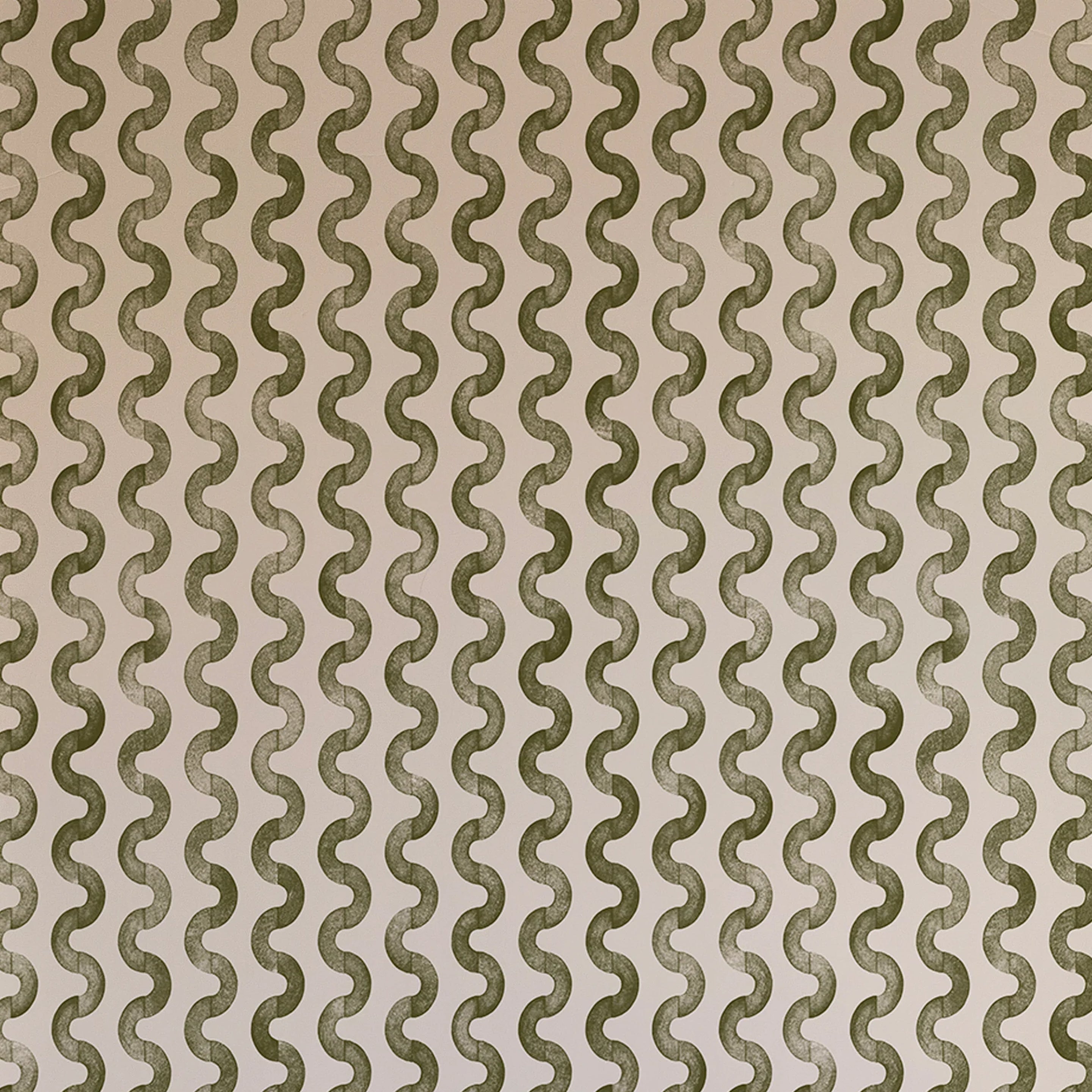 Detail of wallpaper in a playful curvy stripe print in green on a light pink field.