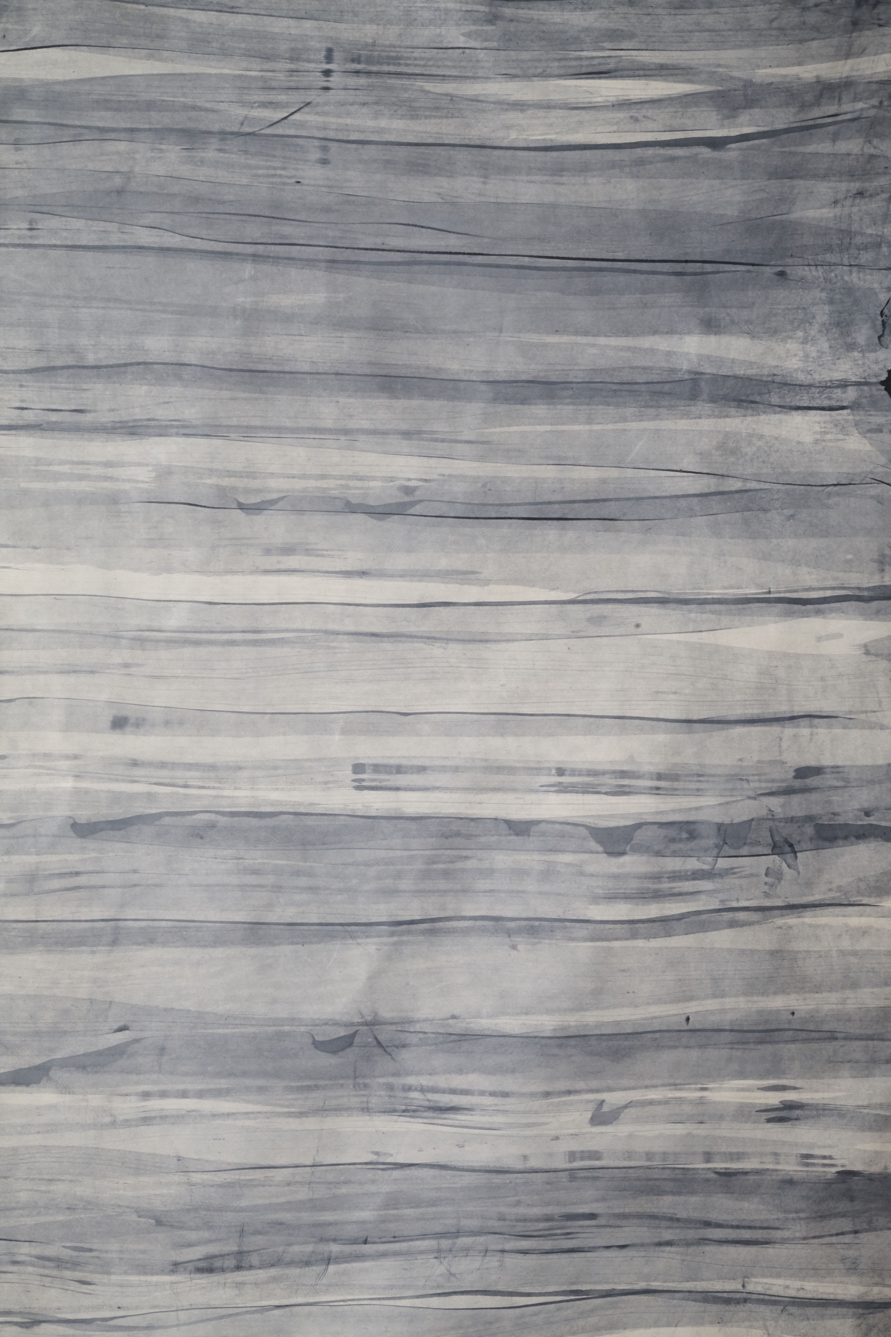 Upholstery leather in gray with an abstract stripe overlay in shades of navy and gray.