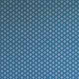 Detail of wallpaper in a minimalist quatrefoil pattern in light pink on a blue field.