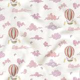 Fabric with pink hot air balloons and clouds pattern on a white background