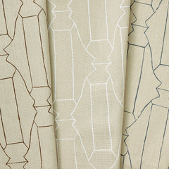 A group of draped woven fabrics, each in a different colorway of a repeating curvolinear print.