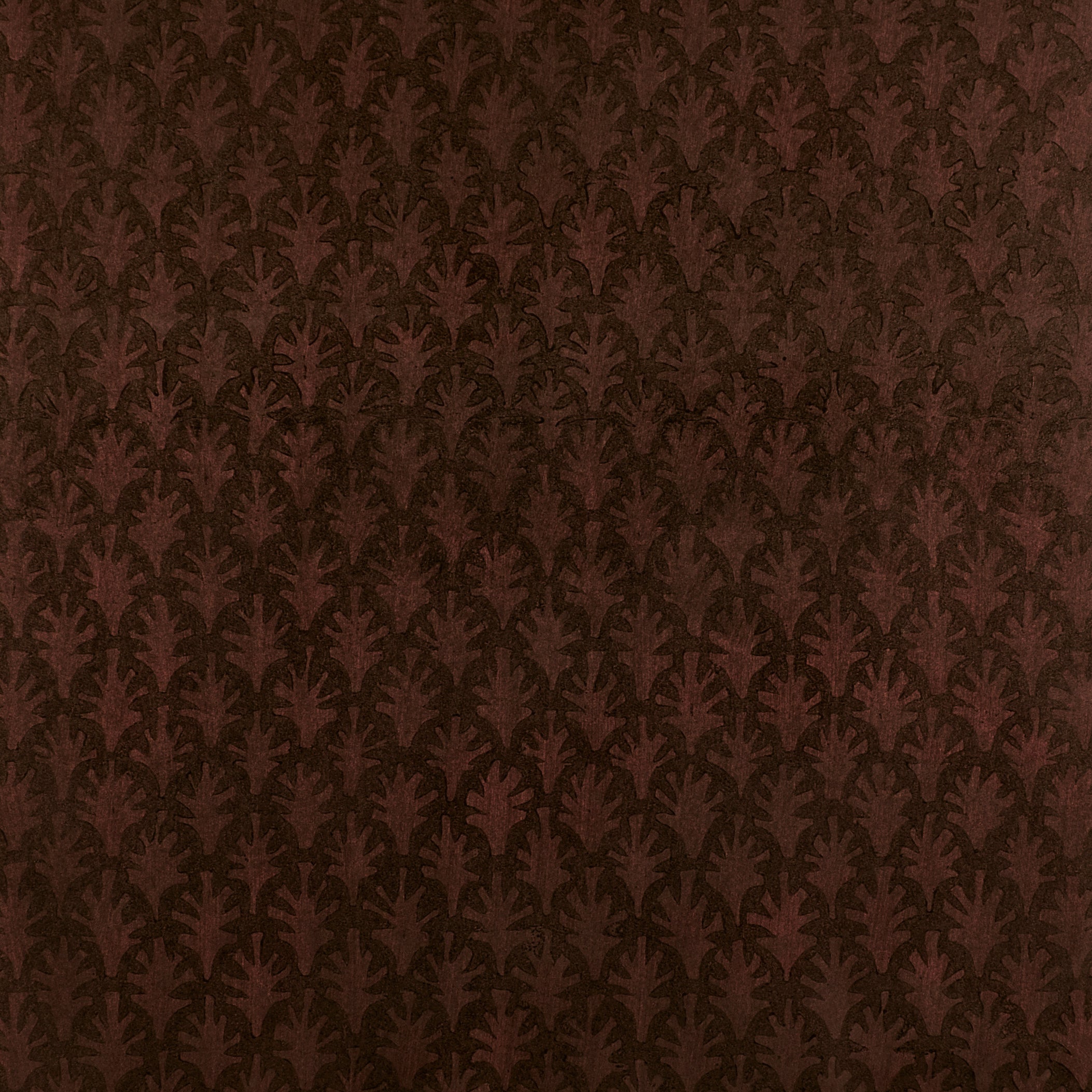 Detail of wallpaper in a repeating botanical grid print in burnt orange on a brown field.