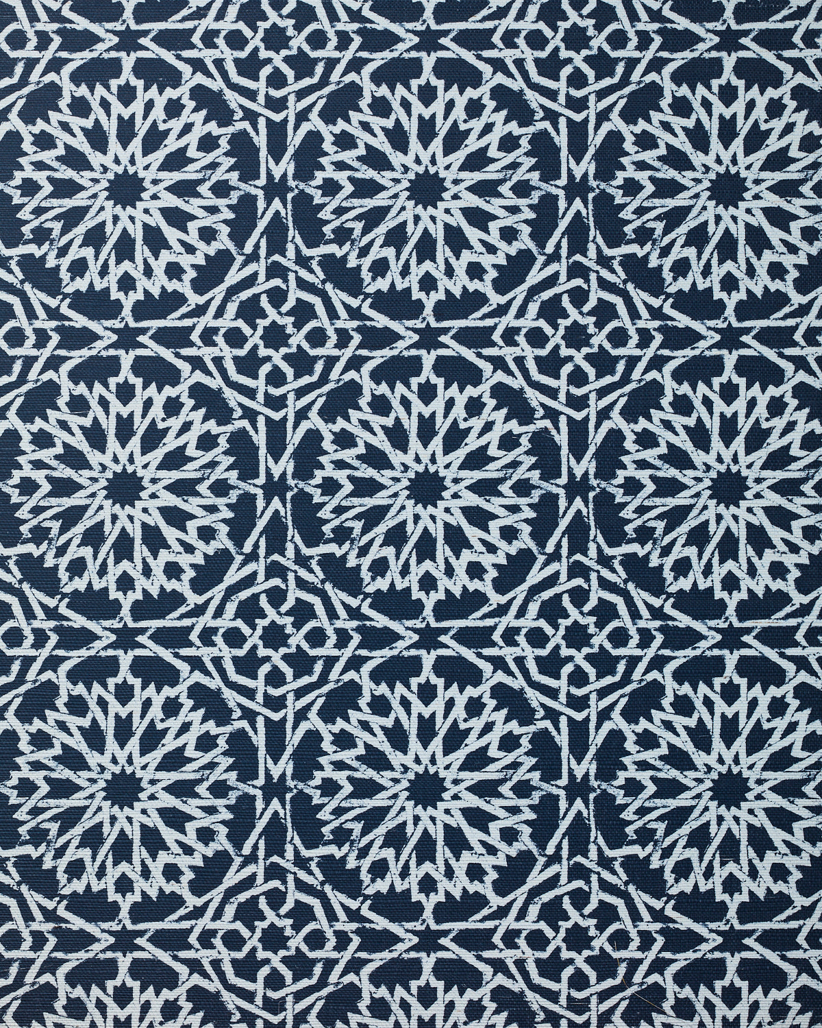 Detail of fabric in a small-scale lattice print in white on an indigo field.