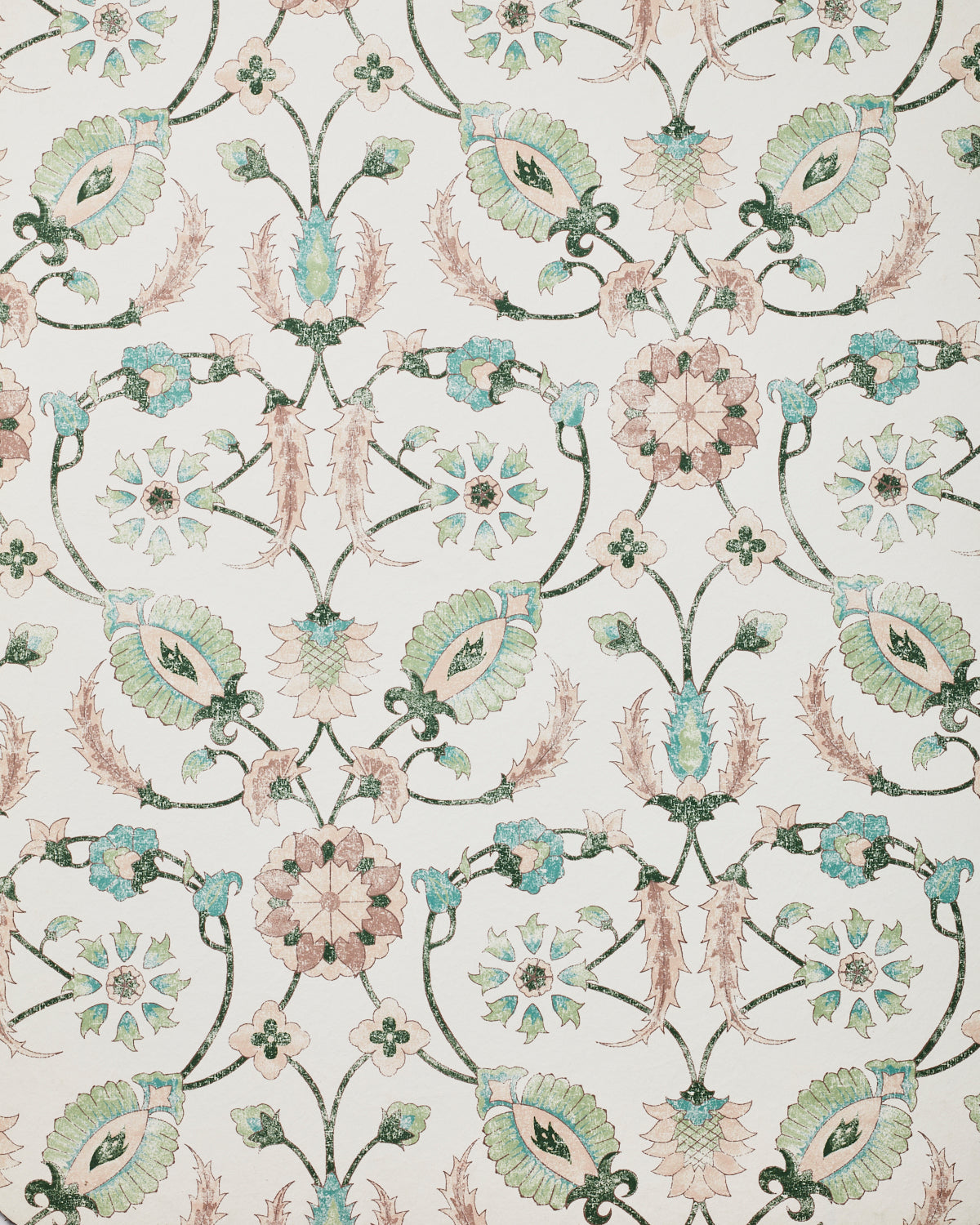 Detail of wallpaper in a floral paisley print in shades of pink and green on a cream field.