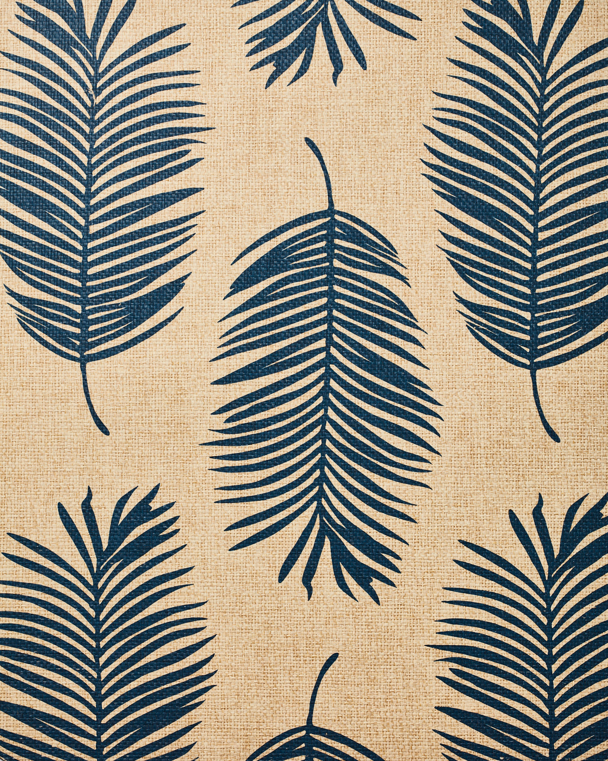 Detail of fabric in a large-scale leaf print in navy on a tan field.