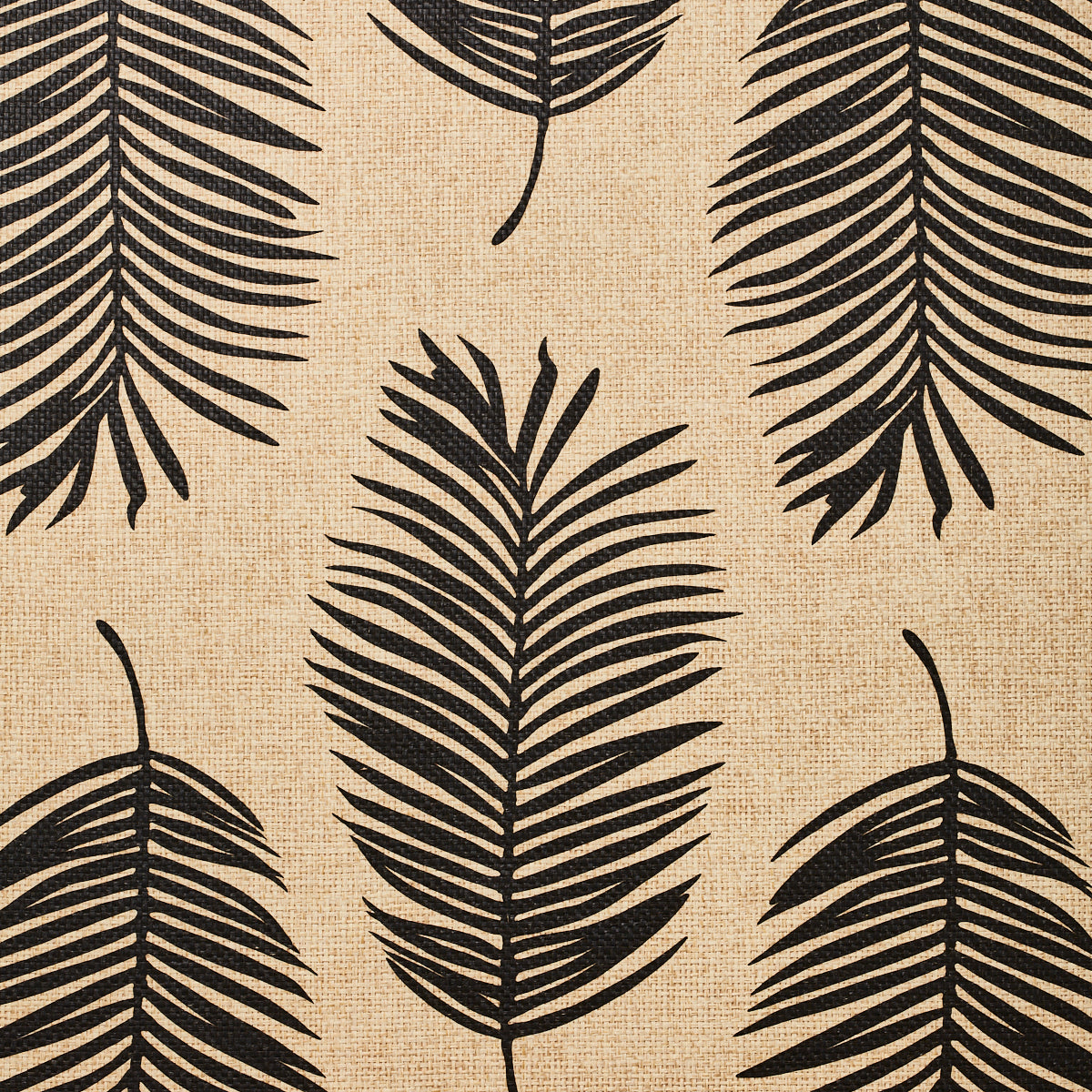 Detail of fabric in a large-scale leaf print in black on a tan field.