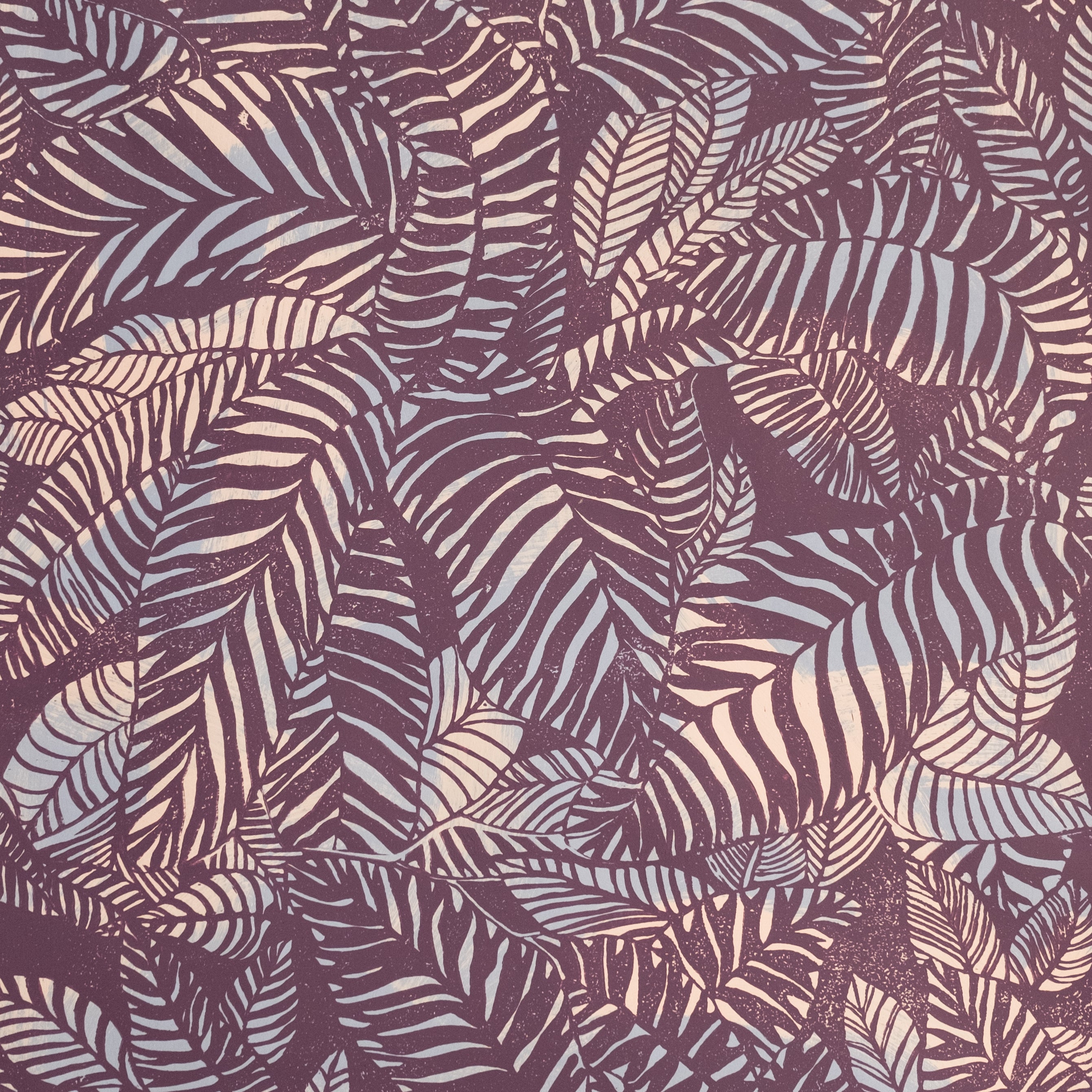 Detail of wallpaper in a dense leaf print in purple and tan on a maroon field.