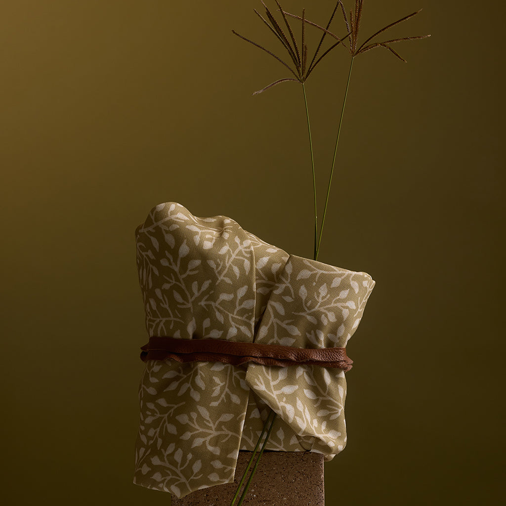 Folded fabric with a plant on a brown background