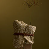 Folded fabric with a plant on a brown background