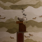 Decorative wall art with a mountain landscape and horses, featuring a central wooden sculpture.