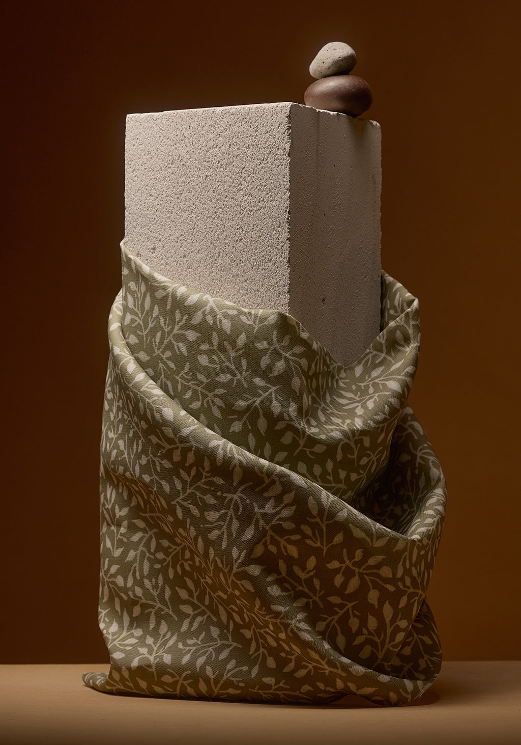 Textured block with a fabric-wrapped base on a brown background
