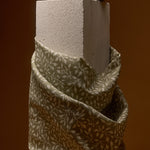 Textured block with a fabric-wrapped base on a brown background