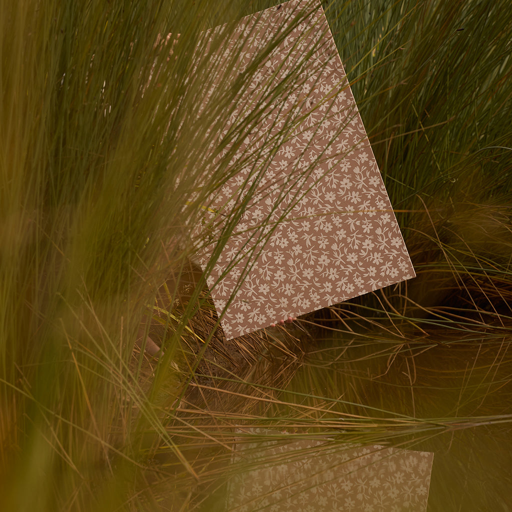 Patterned paper on grass with a warm color tone