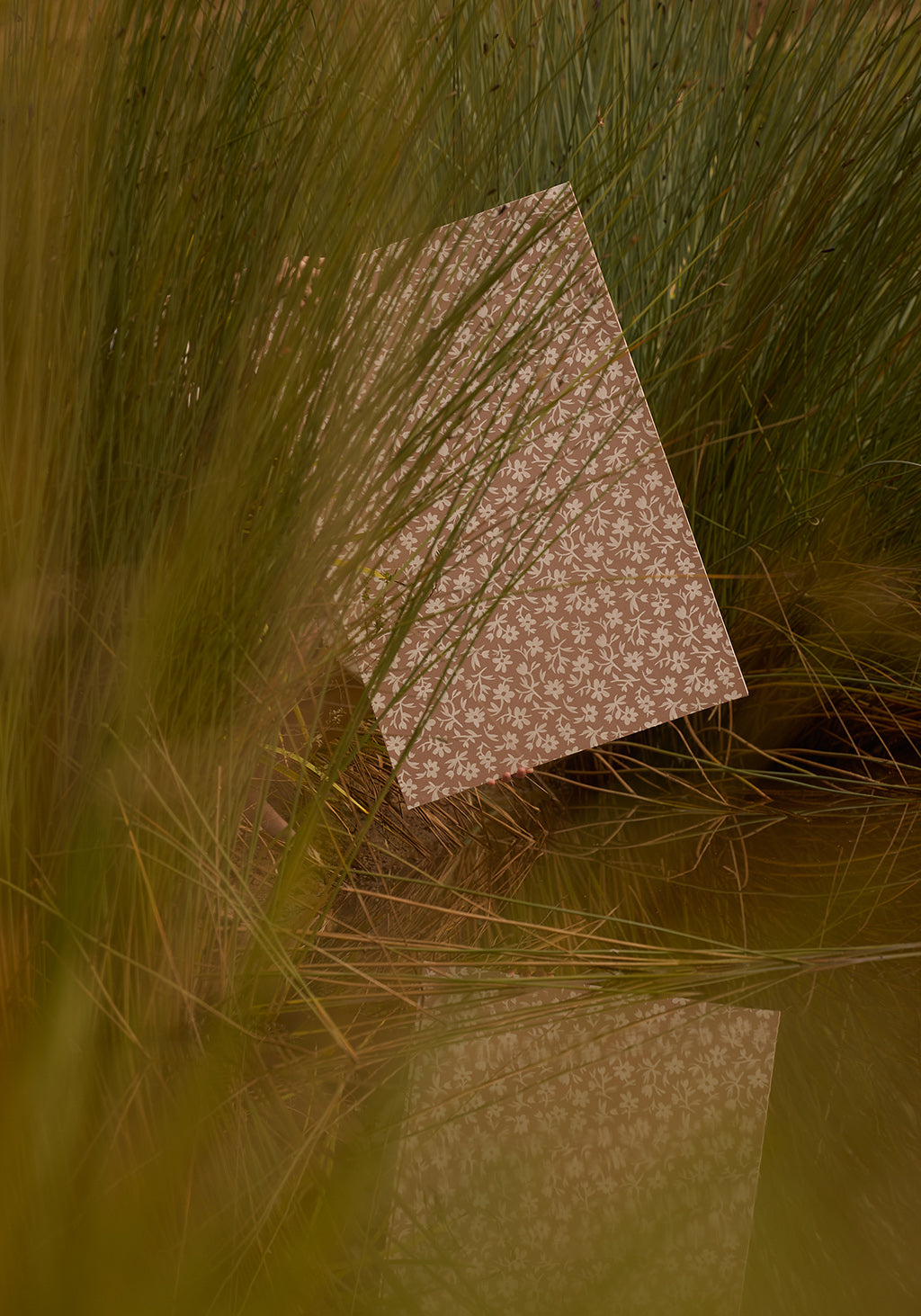 Patterned paper on grass with a warm color tone