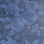 Detail of wallpaper in a minimalist floral print in blue on a mottled navy field.