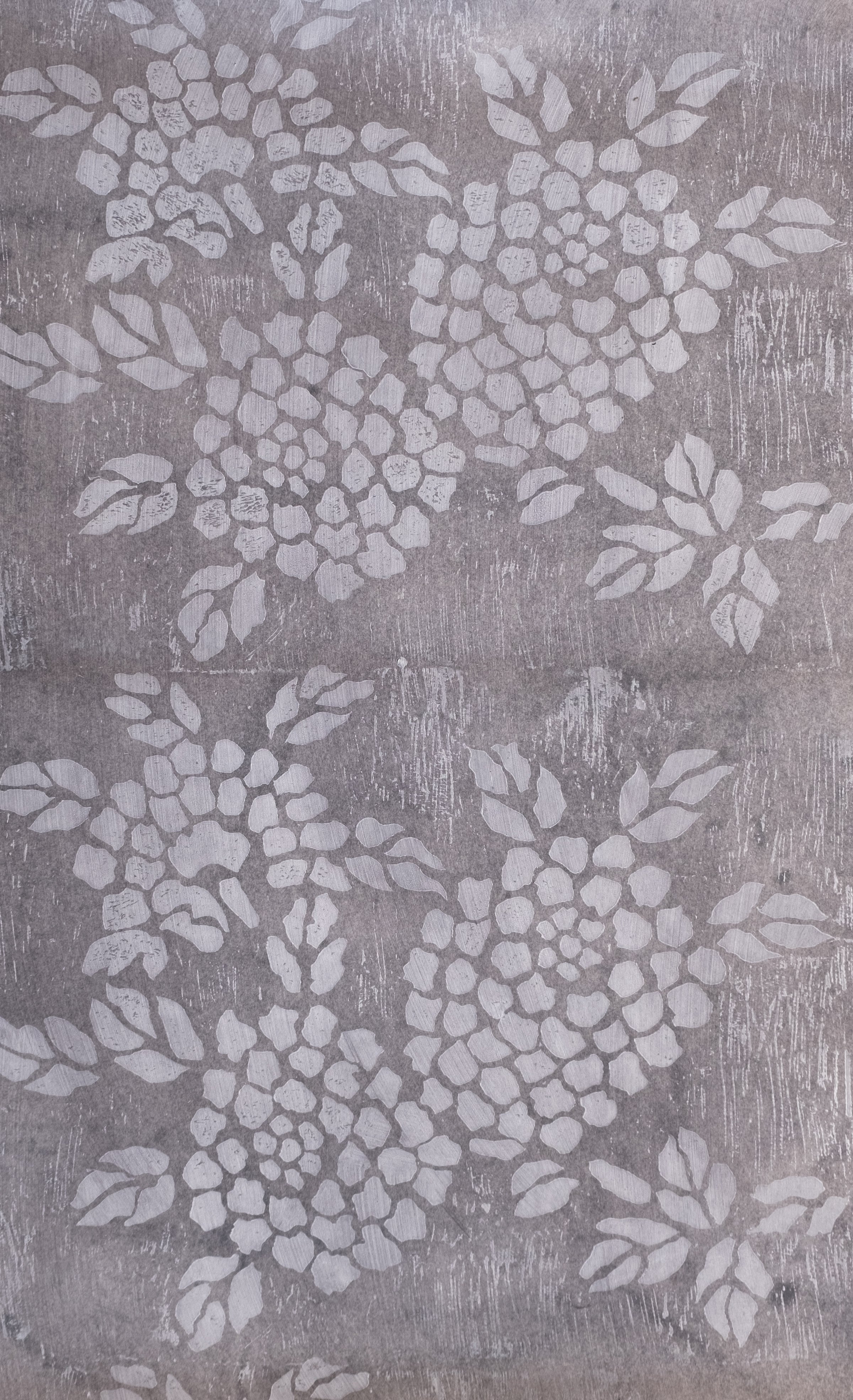 Detail of wallpaper in a minimalist floral print in light gray on a mottled gray field.