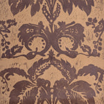 Detail of wallpaper in a repeating floral damask pattern in brown on a tan field.