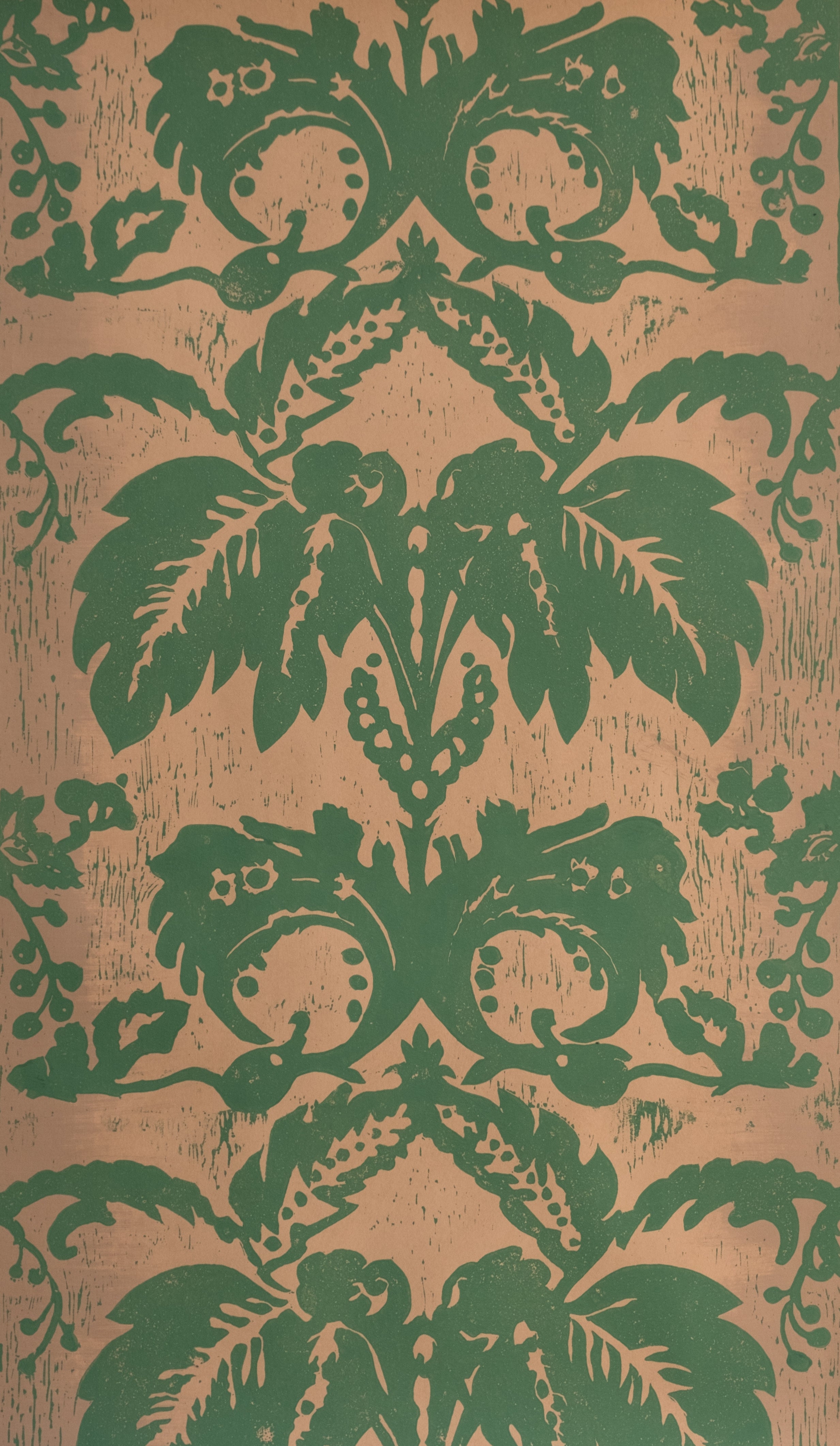 Detail of wallpaper in a repeating floral damask pattern in green on a tan field.