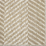 Close up of a woven herringbone design carpet in beige.