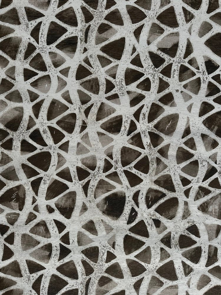 Detail of fabric in an abstract grid print in light gray on a mottled dark gray field.