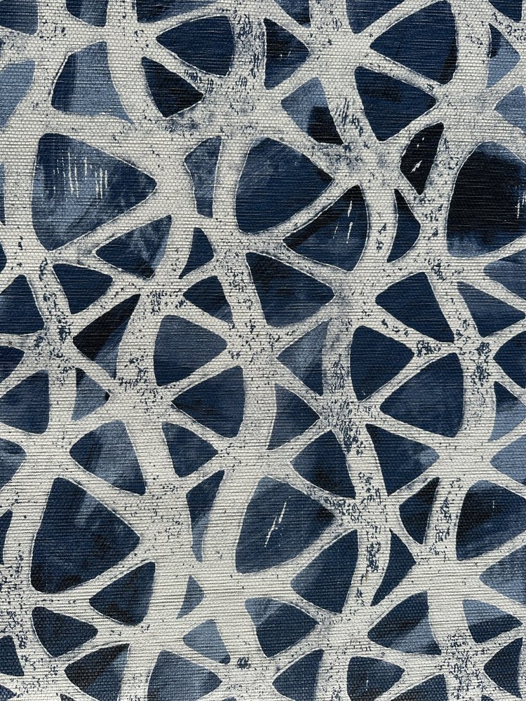 Detail of fabric in an abstract grid print in cream on a mottled navy field.