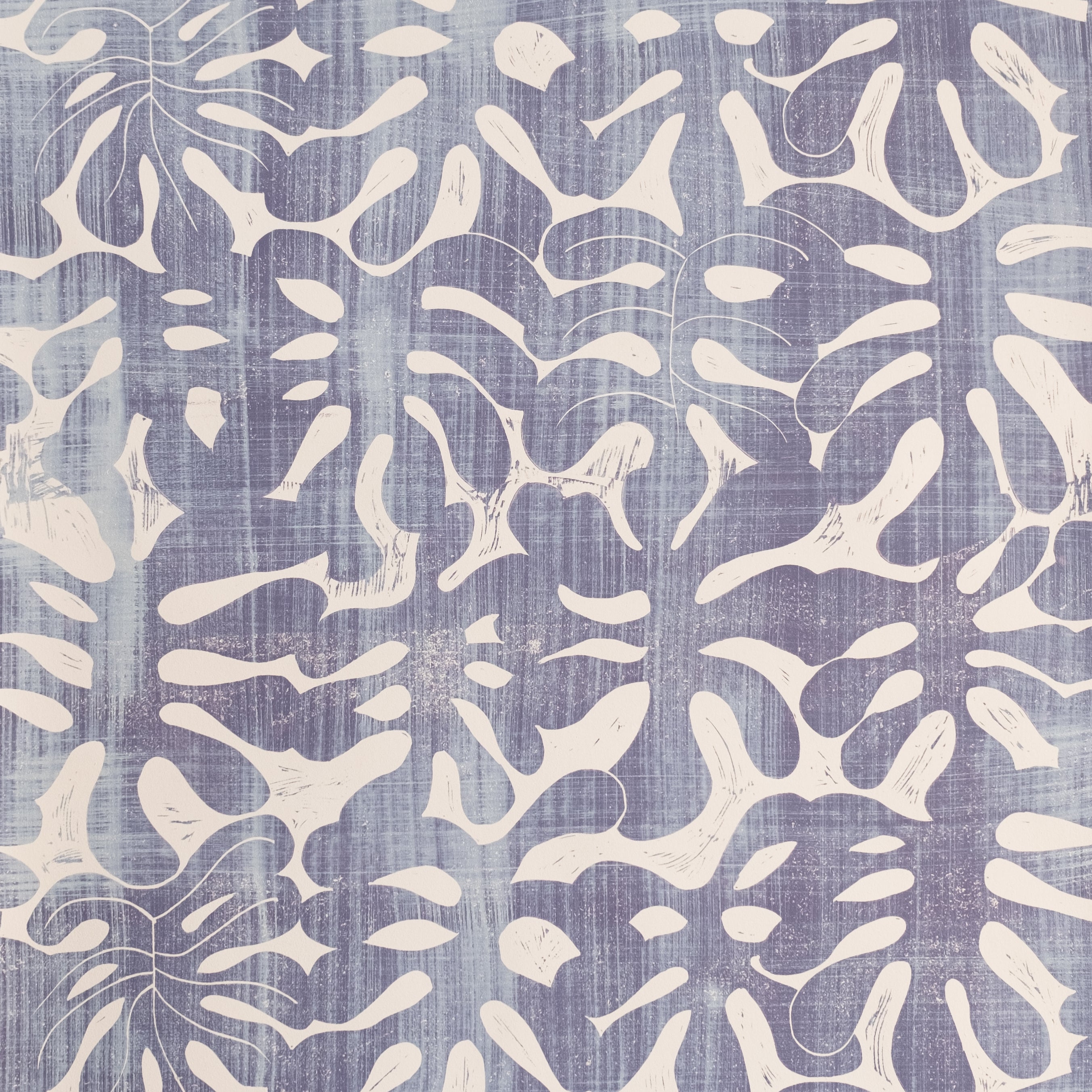 Detail of wallpaper in a playful repeating leaf print in mottled purple on a cream field.