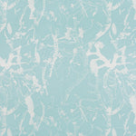 Detail of fabric in a branch and blossom print in cream and blue on a light blue field.