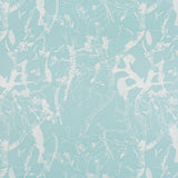 Detail of fabric in a branch and blossom print in cream and blue on a light blue field.