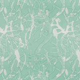 Detail of fabric in a branch and blossom print in white and green on a light green field.