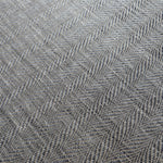 Detail of a woven leather rug in a striped wave texture in shades of gray with cream accents.