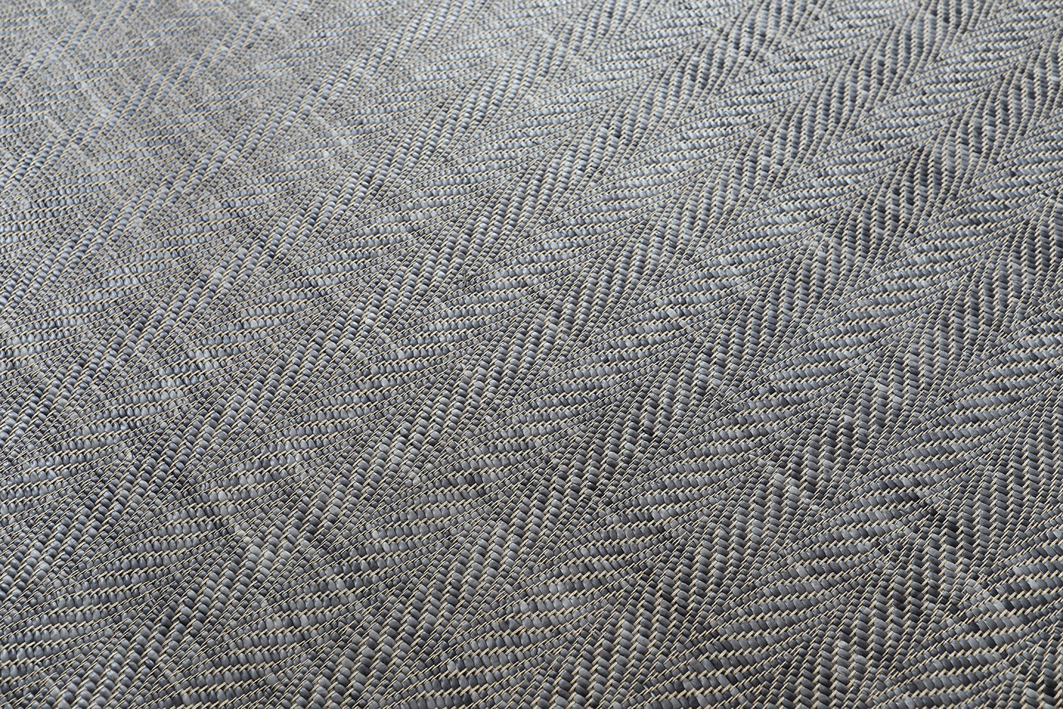 Detail of a woven leather rug in a striped wave texture in shades of gray with cream accents.