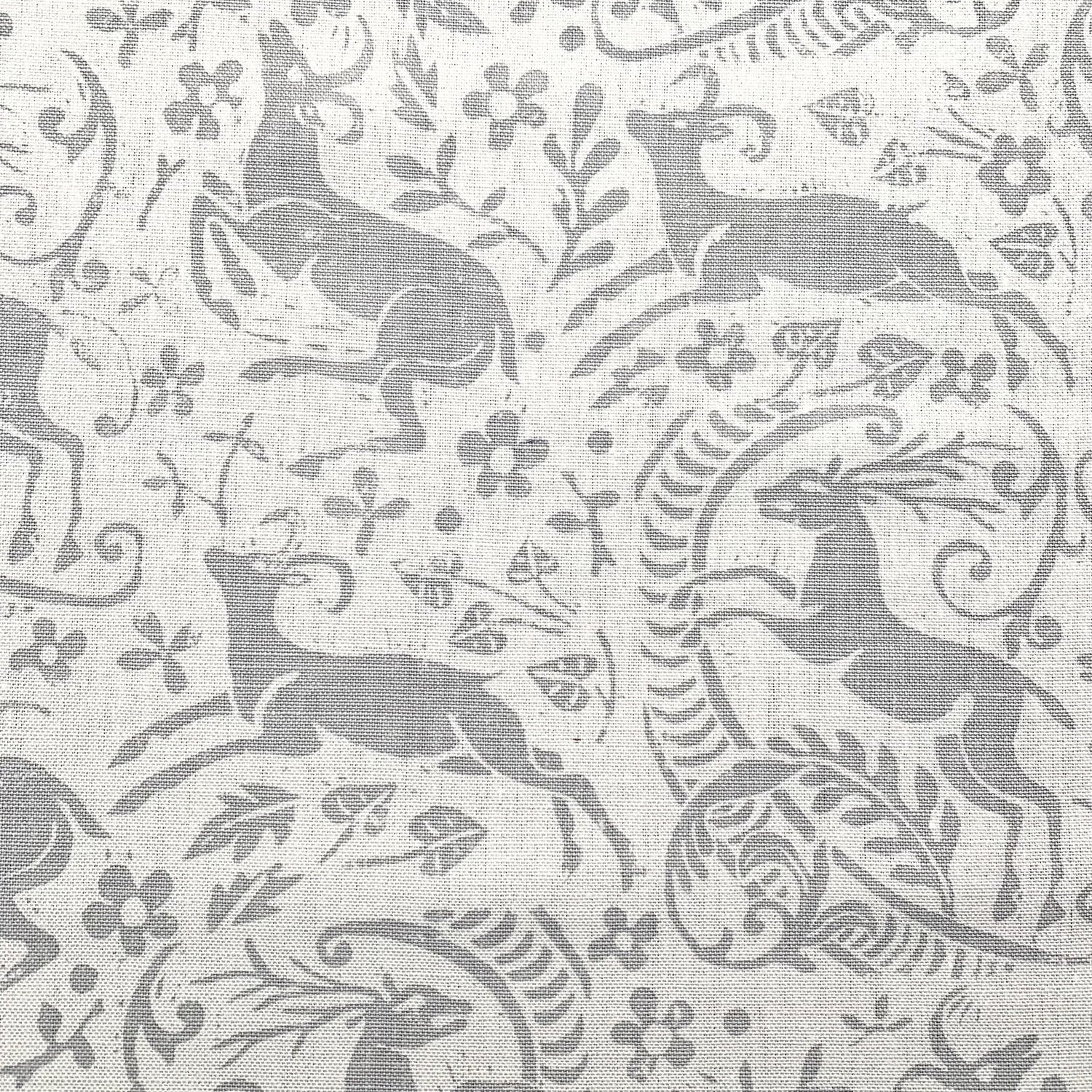 Detail of fabric in a deer, leaf and flower print in gray on a white field.