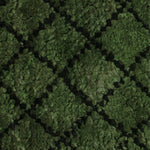 Close up for a handknotted rug in a black lattice design on a green field. 