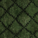 Close up for a handknotted rug in a black lattice design on a green field. 