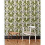 Chair and stool in front of a wall papered in a large, painterly vase and leaf print over a repeating diamond background in shades of green and blue.