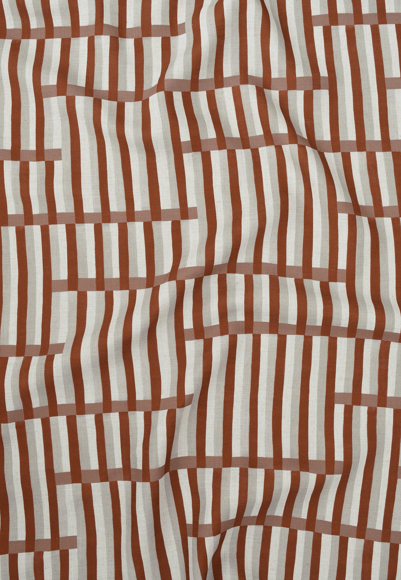 Gently draped printed linen in a broken stripe design in red, ecru, clay pink and cream. 