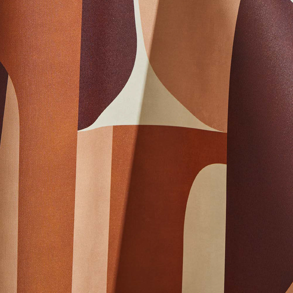 Draped wallpaper yardage in a curvilinear geometric grid print in shades of brown, rust and peach on a cream field.