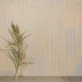 Detail of wallpaper in a muted stripe pattern in pink on a cream field.