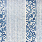 Detail of fabric in a painterly stripe print in navy and blue on a cream field.