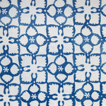 Detail of fabric in a botanical lattice print in blue on a white field.