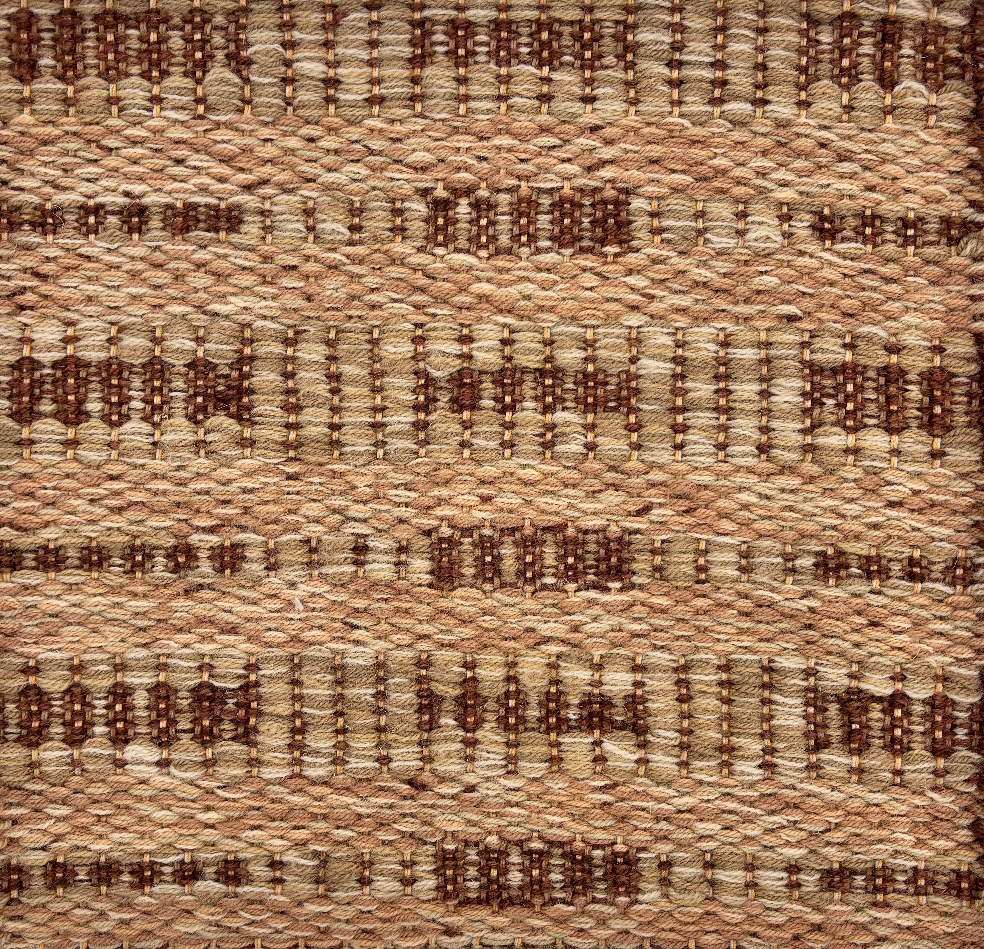 Handwoven rug sample in a abstract geometric pattern in tan and brown