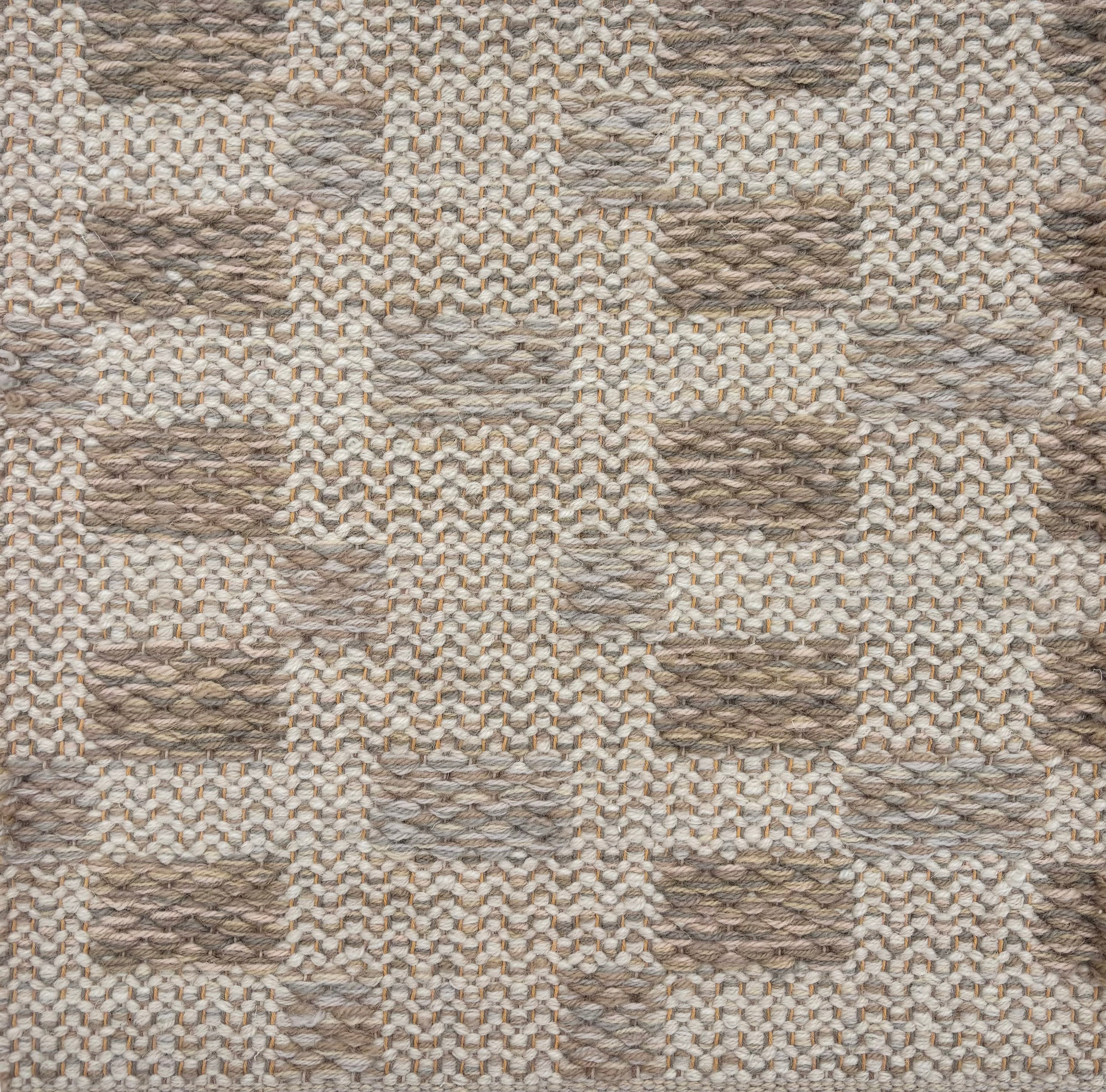 Handwoven rug sample in an irregular  checker pattern in shades of cream, oatmeal and taupe. 