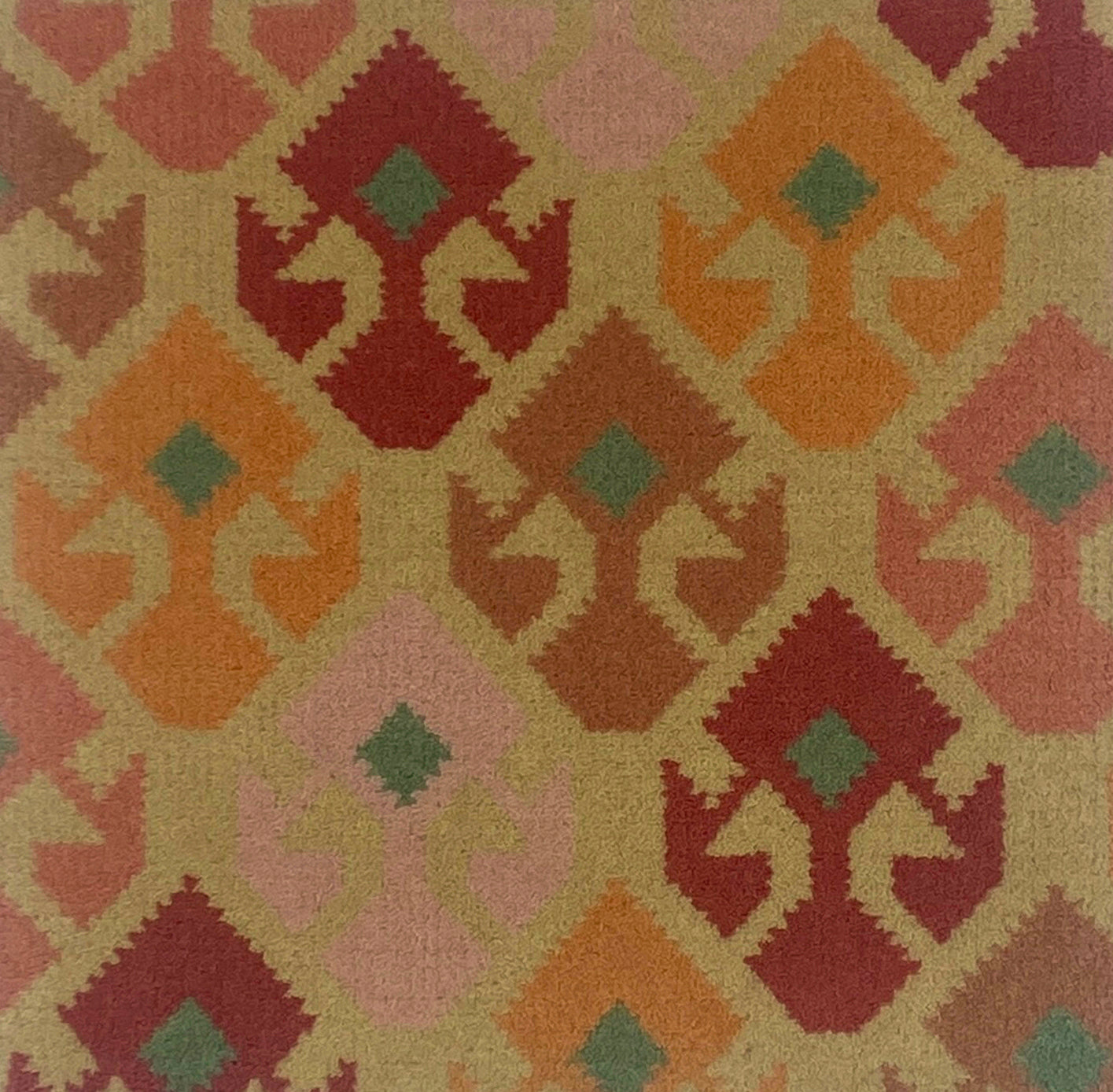 Handknotted rug with geometric design in red, orange, and green on a beige background