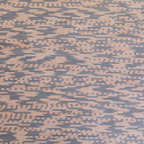 Detail of handwoven leather in a graphic geometric pattern in tan and grey.