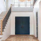 An airy entryway and stairwell space with a cowhide rug in light blue with a painterly flower print in yellow and coral.