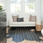 Detail of a cozy bedroom sitting area with a cowhide rug in black with a tan geometric overlay.