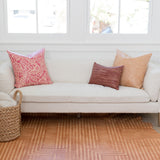 A bright living space with a large cowhide rug in tan with a geometric stripe overlay in cream.