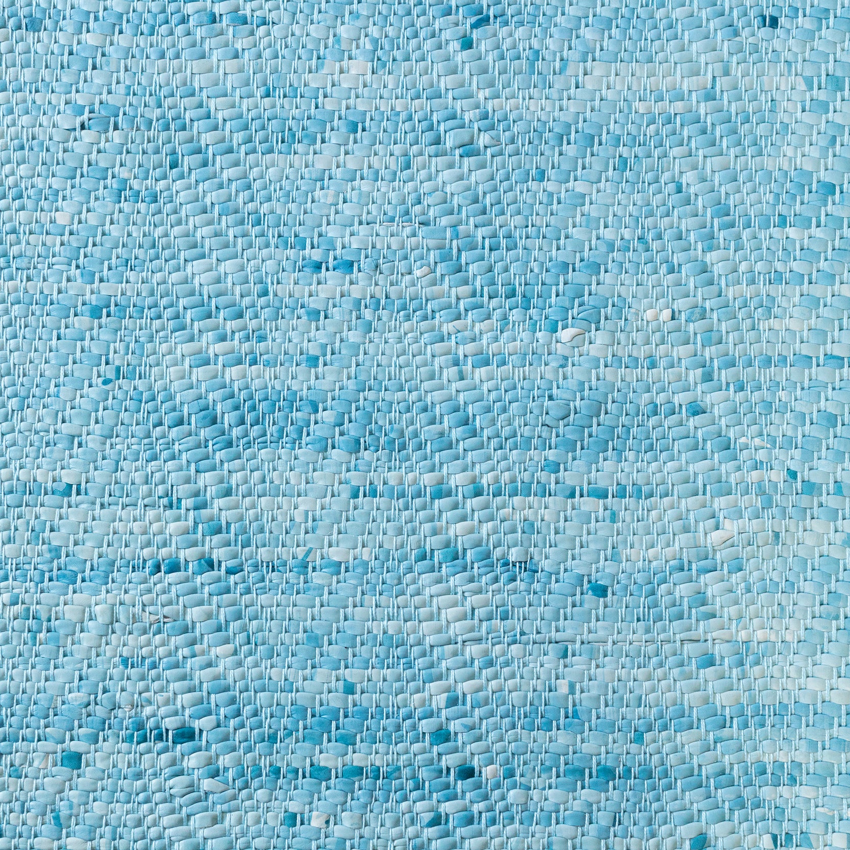 Detail of a woven leather rug in a striped wave texture in shades of turquoise with cream accents.